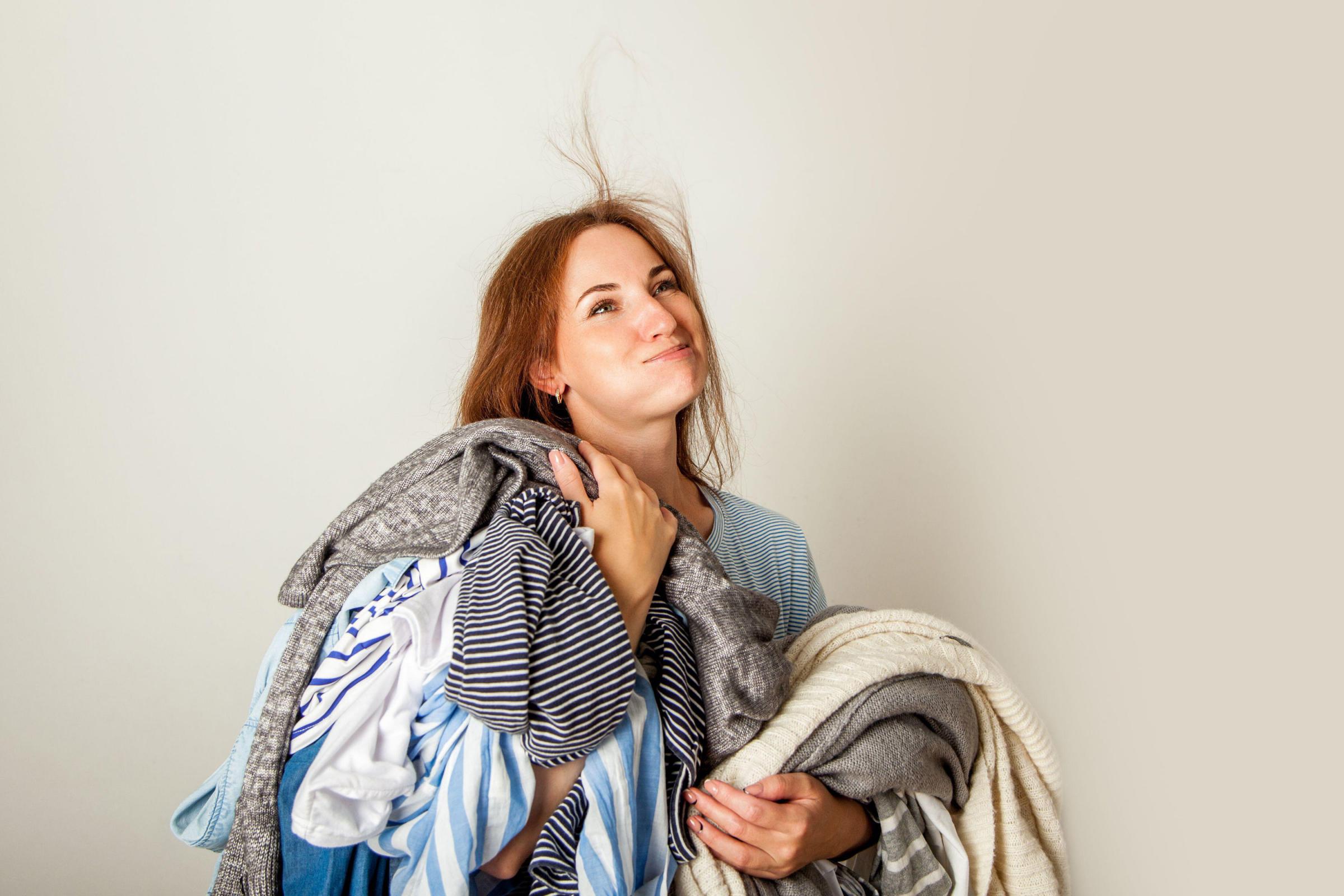 A Generic Photo of woman holding a pile of messy clothes. See PA Feature TOPICAL Fashion Decluttering. Picture credit should read: Alamy/PA. WARNING: This picture must only be used to accompany PA Feature TOPICAL Fashion Decluttering. 